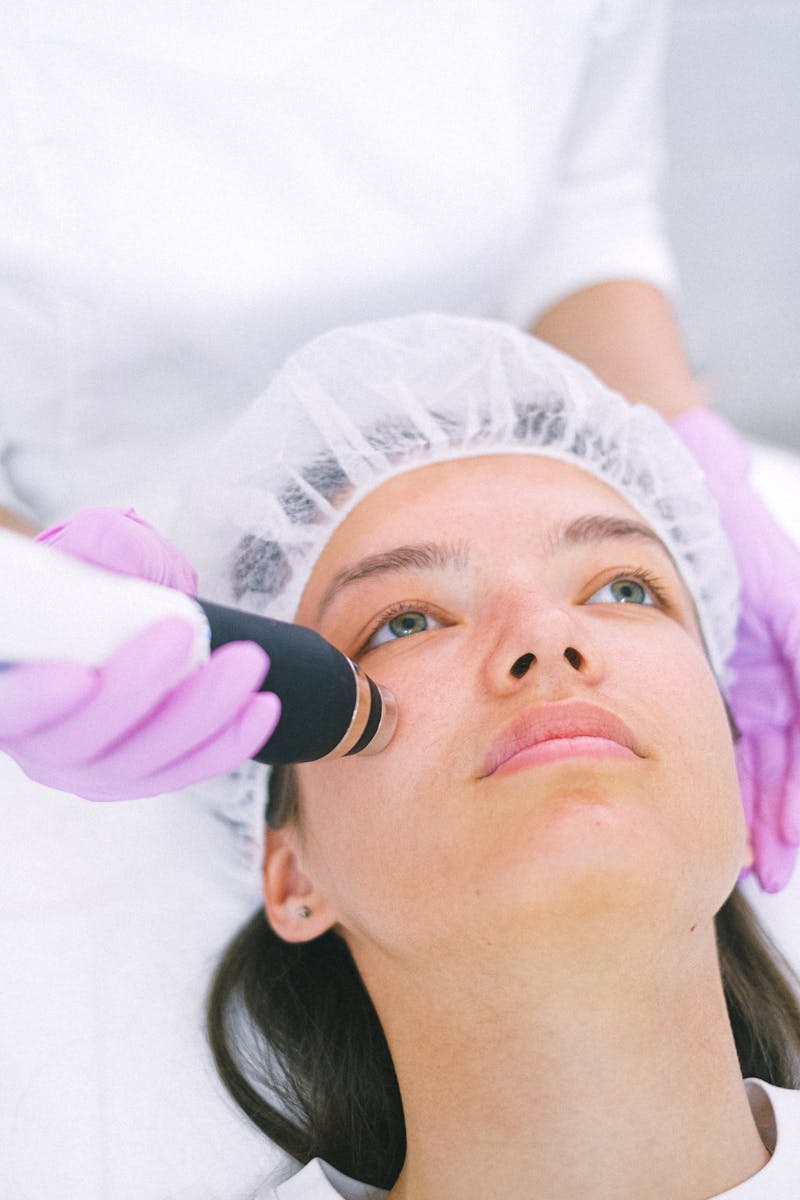Photo by Anna Shvets Close-up of a woman receiving a laser facial treatment by an aesthetician with protective gloves.